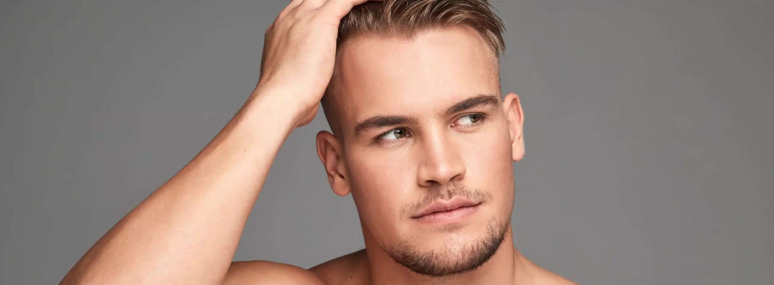 Photo de profile d jeune homme se touchant les cheveux greffe de cheveux fut ou fue comment choisir | Dr Christophe Reinbold Lyon