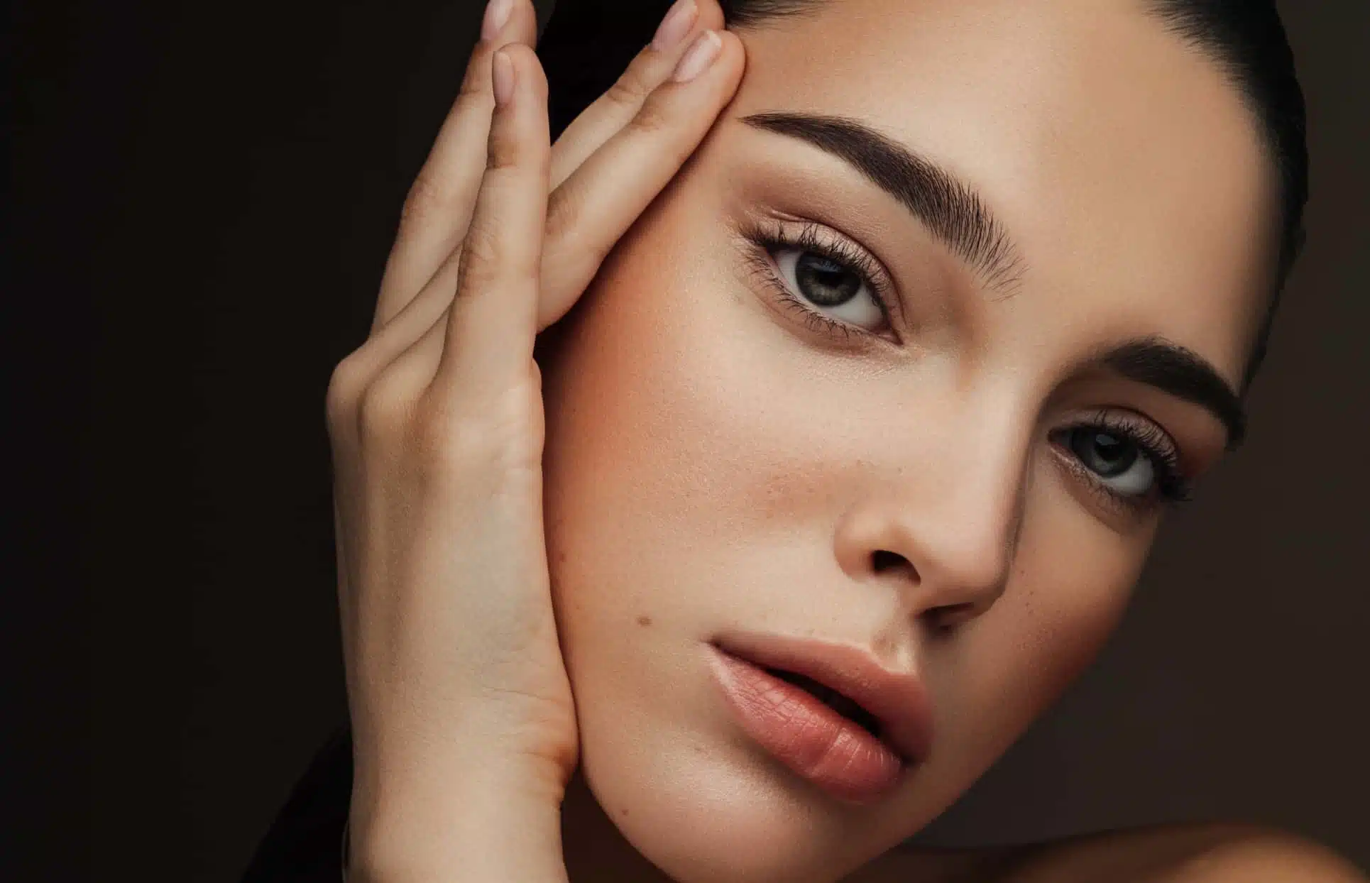 Photo rapprochee du visage d une femme posant sa main sur sa joue Botox | Dr Christophe Reinbold Lyon