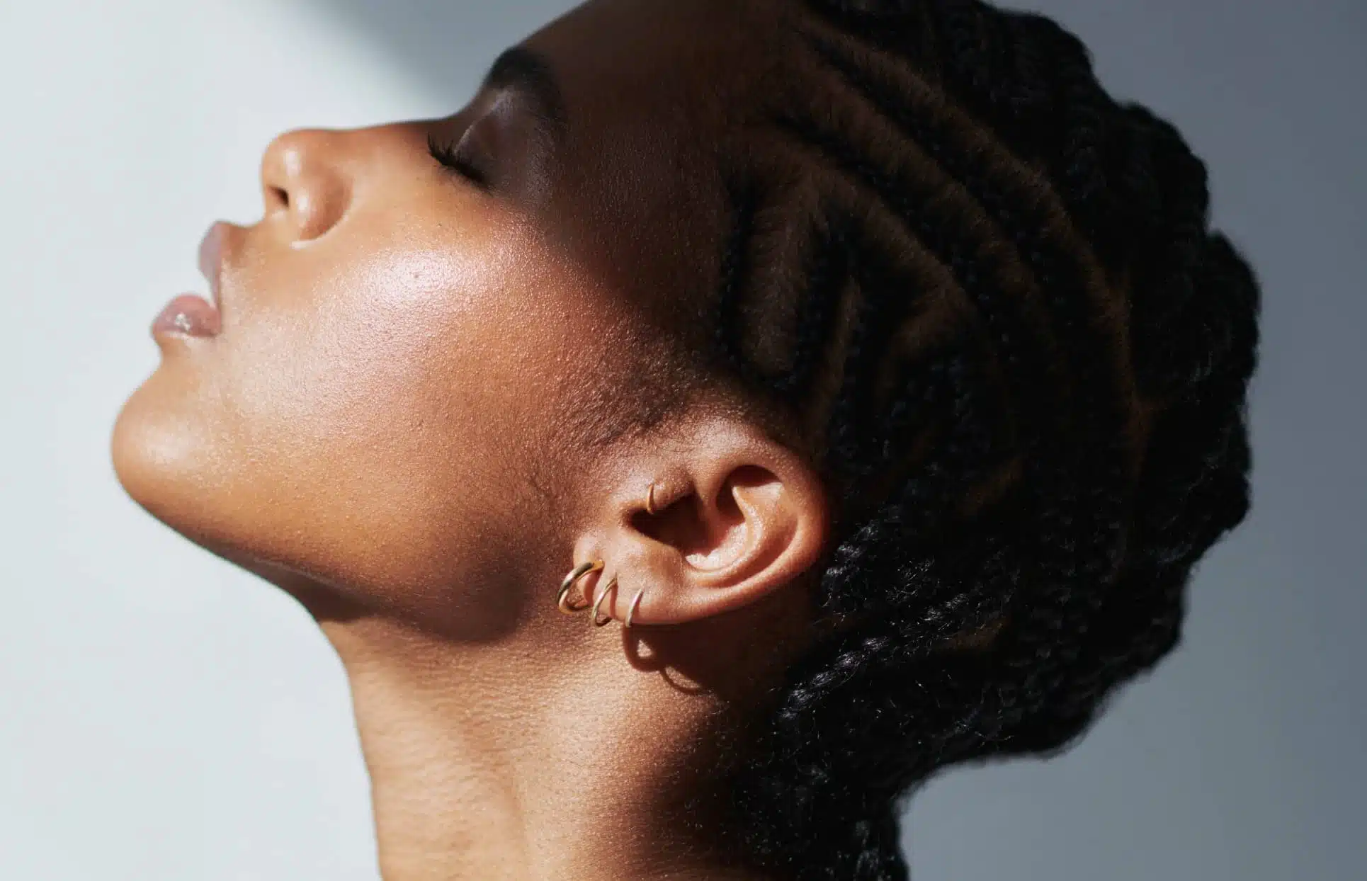 Photo stylisee de profile gauche du visage d une femme noire chirurgie du lobe de l oreille | Dr Christophe Reinbold Lyon