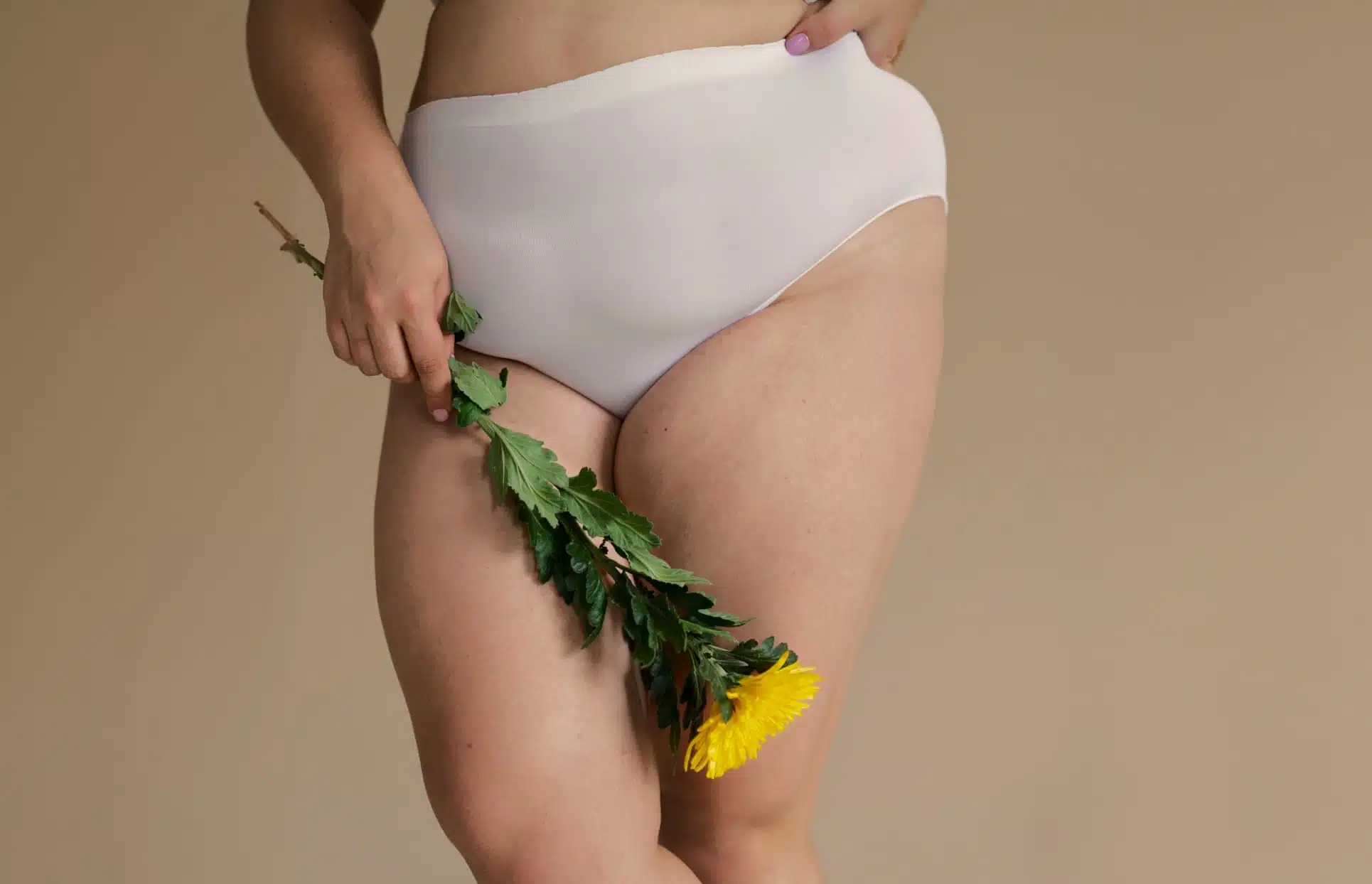 Photo rapprochee des cuisses d une femme tenant des fleurs dans sa main et qui a des lipœdeme | Dr Christophe Reinbold Lyon