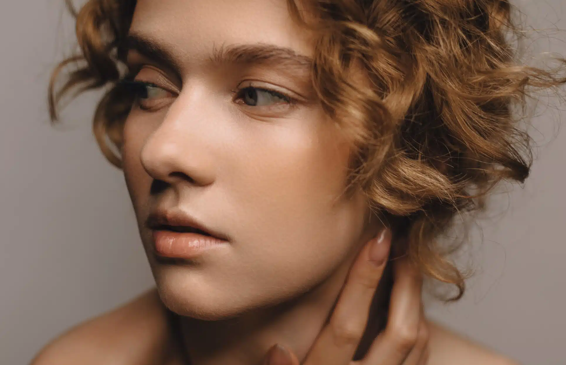 Photo stylisee du visage d une jeune femme posant sa main sur le cou lipofilling du visage | Dr Christophe Reinbold Lyon