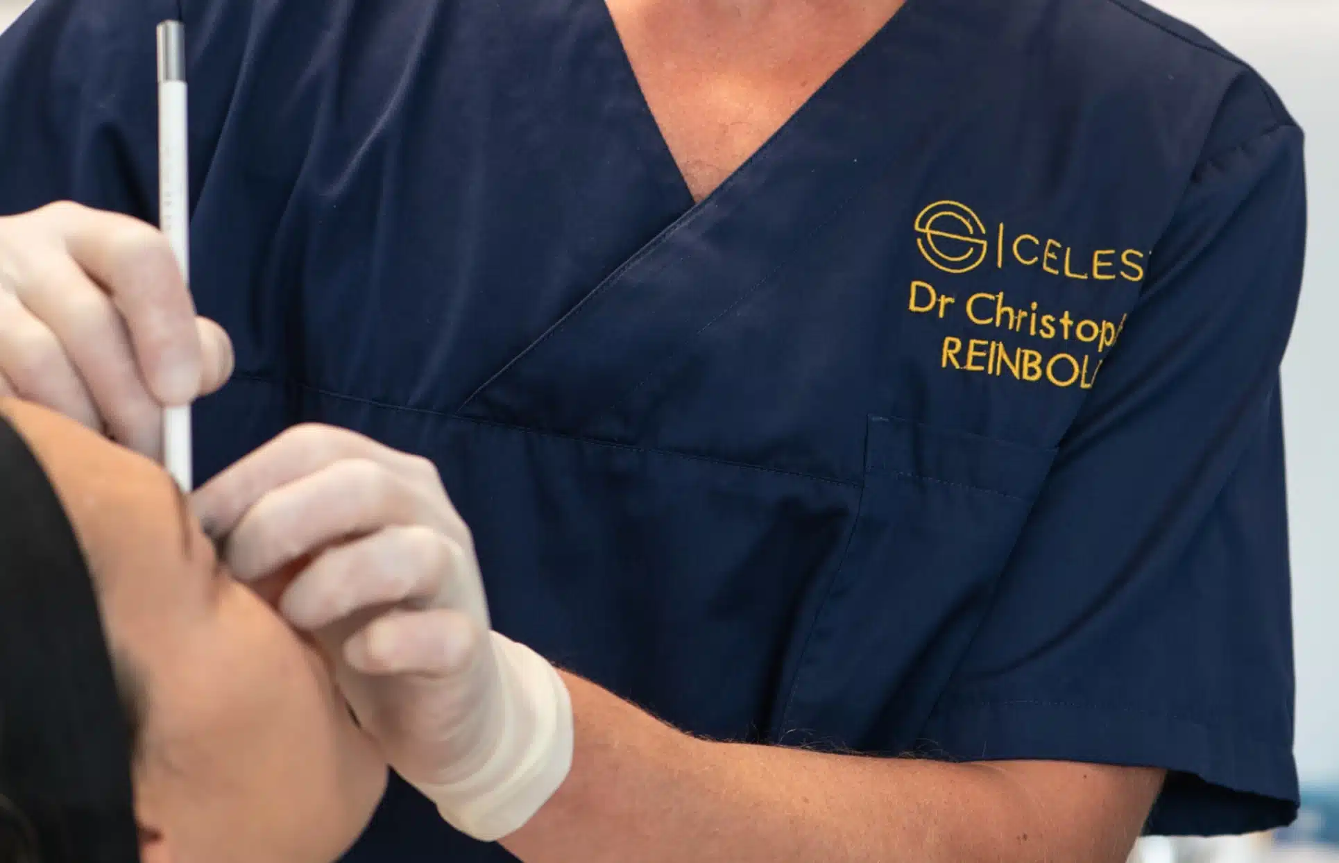 Photo d un professionnel faisant des marque avec crayon sur le visage d une patiente simulation en 3 etapes | Dr Christophe Reinbold Lyon