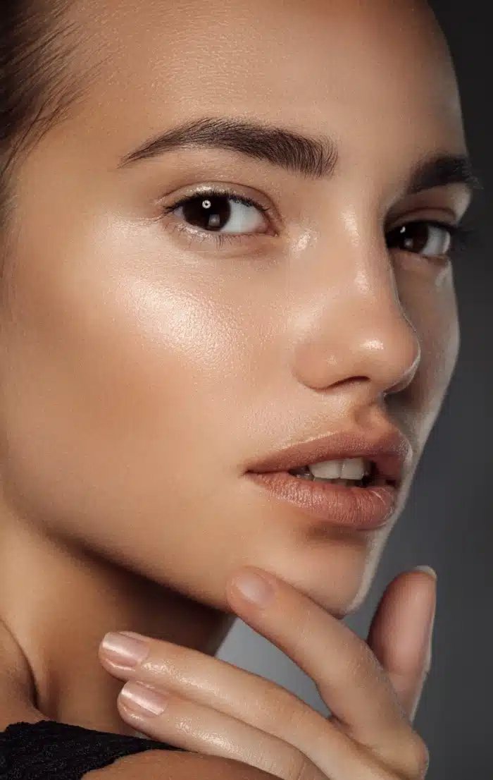 Visage d une jolie femme posant son doigt sur son menton les injections en medecine esthetique | Dr Christophe Reinbold Lyon