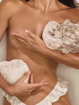 Vue de profil face d’une femme avec les bras croisés sur la poitrine - chirurgie mammaire - Dr Reinbold | Lyon